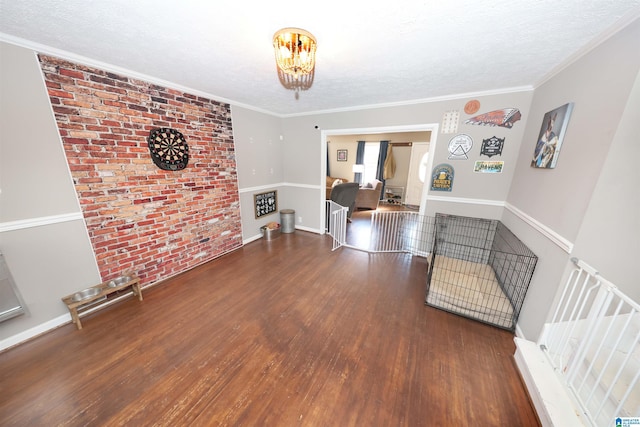 interior space featuring a textured ceiling, dark hardwood / wood-style floors, and crown molding