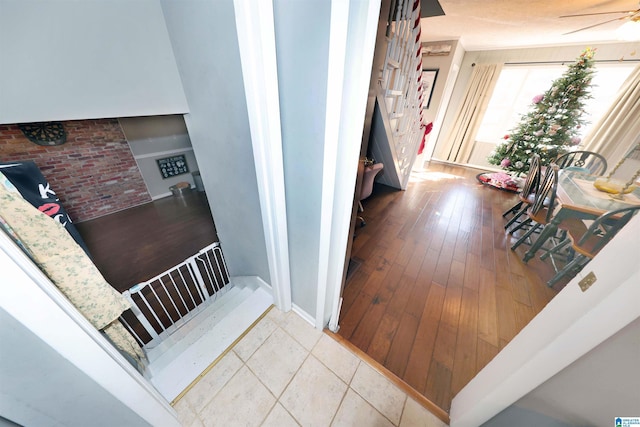 stairs with wood-type flooring and ceiling fan