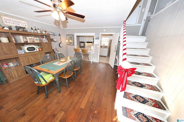 dining space featuring a textured ceiling, ceiling fan, crown molding, dark wood-type flooring, and sink