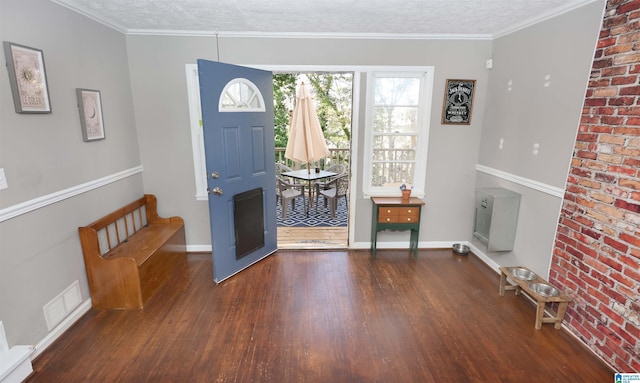 foyer with dark hardwood / wood-style flooring, ornamental molding, and a textured ceiling