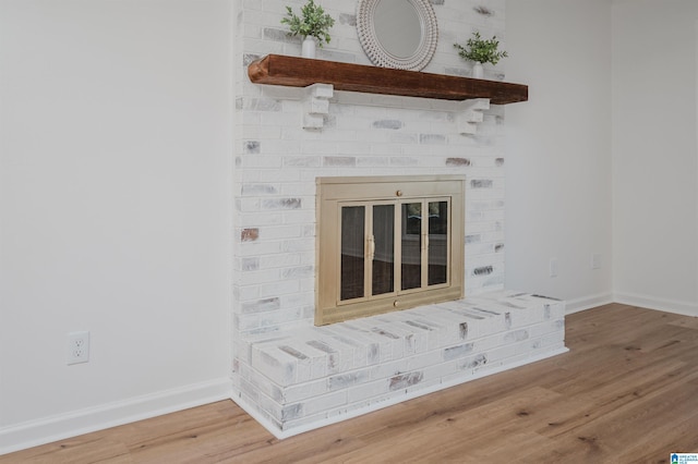 details with wood-type flooring and a brick fireplace