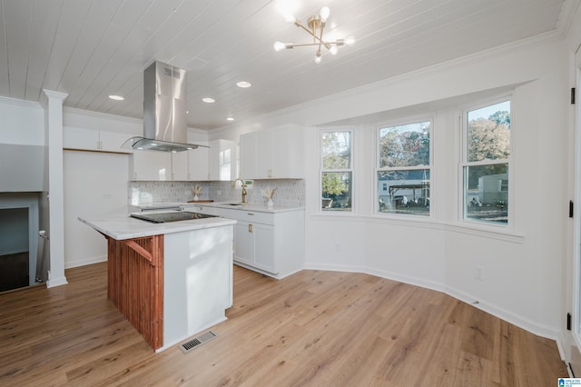 kitchen featuring island exhaust hood, light hardwood / wood-style flooring, white cabinets, and a kitchen island