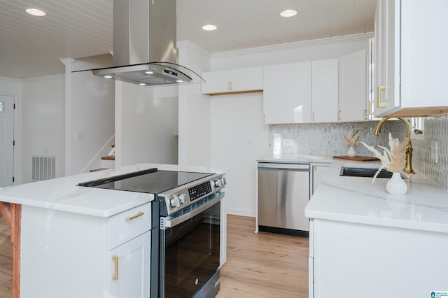 kitchen featuring white cabinets, island exhaust hood, light hardwood / wood-style floors, a kitchen island, and appliances with stainless steel finishes