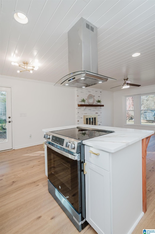 kitchen featuring island exhaust hood, ceiling fan, light hardwood / wood-style flooring, white cabinetry, and stainless steel electric range