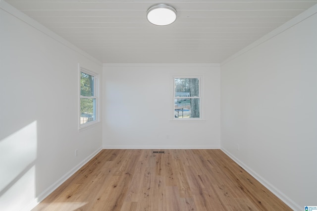 empty room featuring light hardwood / wood-style floors and crown molding