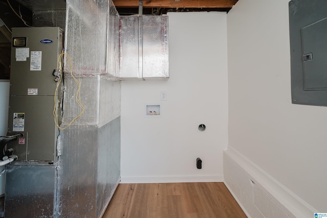 laundry room with hardwood / wood-style floors, washer hookup, electric panel, and heating unit