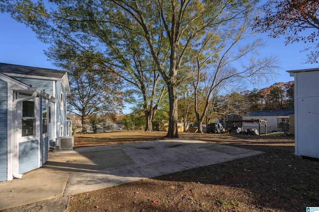 view of yard with central AC unit and a patio area