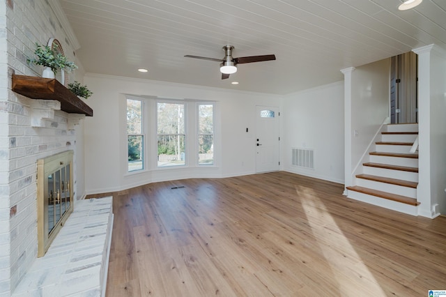 unfurnished living room featuring a brick fireplace, ornamental molding, ceiling fan, light hardwood / wood-style flooring, and wooden ceiling