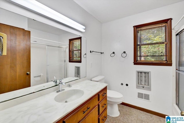 bathroom with vanity, tile patterned floors, toilet, a shower with shower door, and heating unit