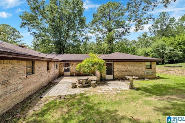 rear view of house featuring a lawn and a patio area