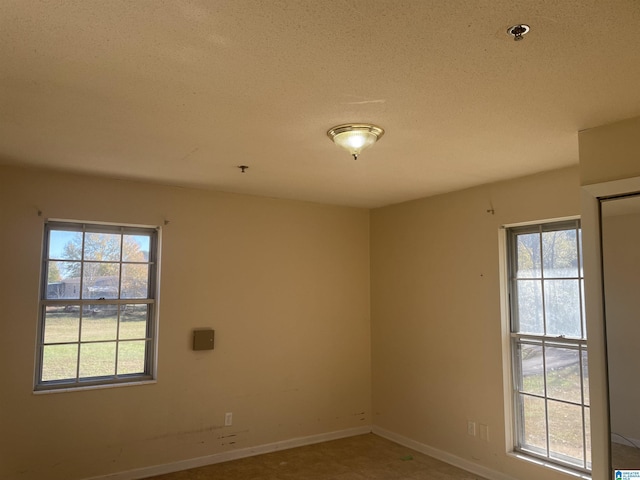 spare room with a textured ceiling and plenty of natural light