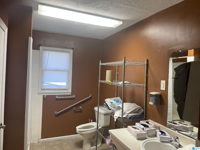 bathroom with a shower with shower curtain, vanity, a textured ceiling, tile patterned flooring, and toilet