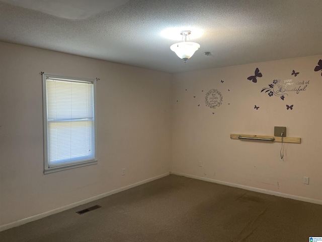 spare room with a textured ceiling and carpet floors