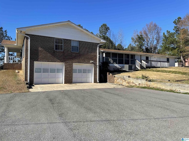 view of front of home featuring a garage and a sunroom