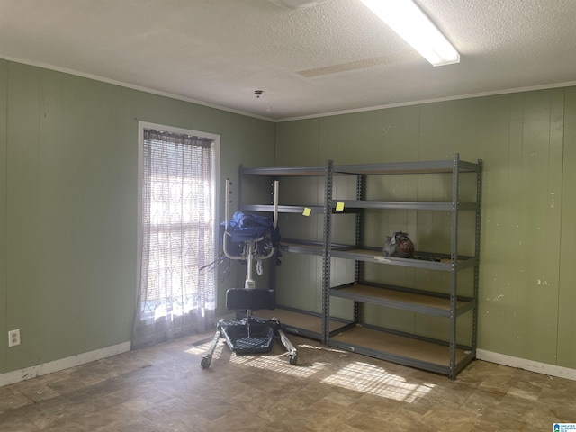 interior space featuring crown molding, wooden walls, and a textured ceiling