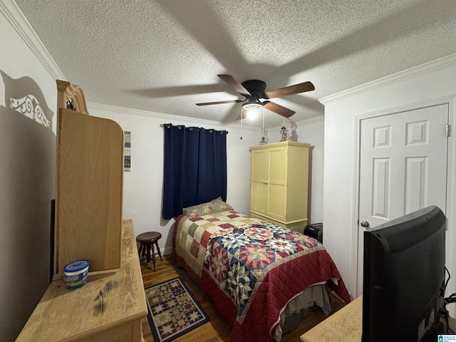 bedroom with ceiling fan, crown molding, wood-type flooring, and a textured ceiling