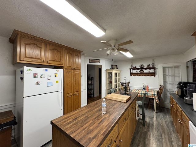 kitchen with french doors, white appliances, a textured ceiling, dark wood-type flooring, and butcher block counters