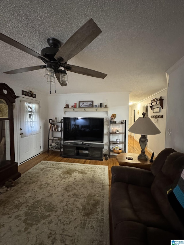 unfurnished living room with hardwood / wood-style floors, a textured ceiling, ceiling fan, and crown molding