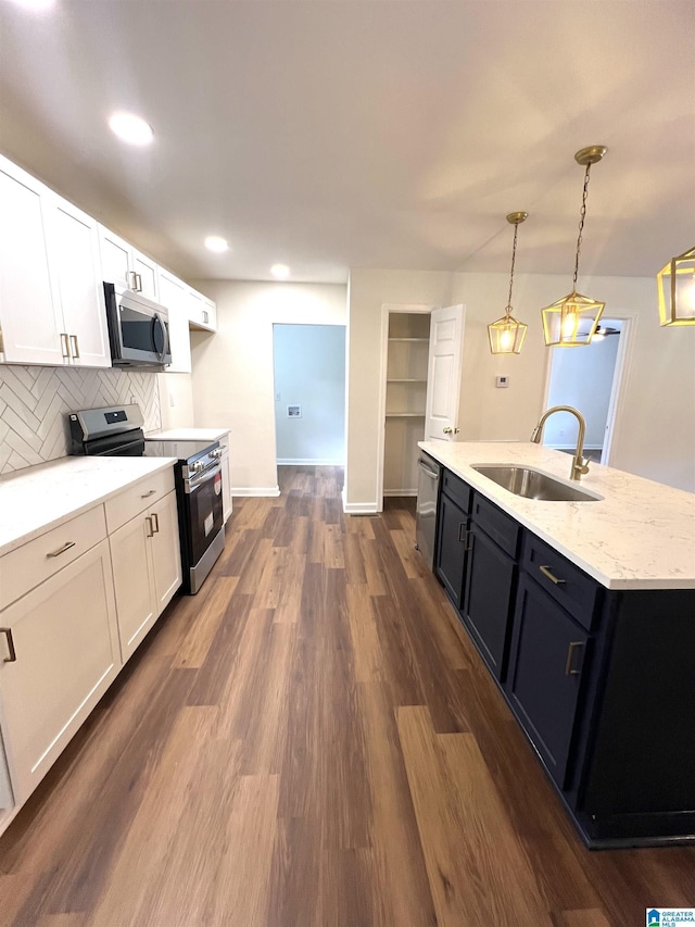 kitchen with appliances with stainless steel finishes, white cabinetry, pendant lighting, and sink