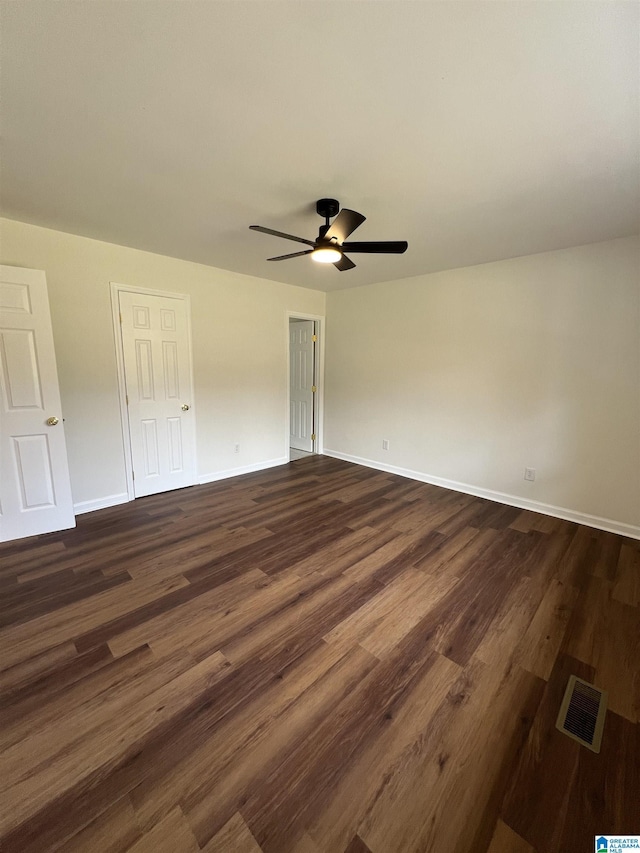 unfurnished bedroom with ceiling fan and dark wood-type flooring