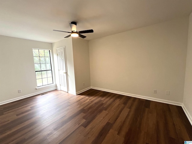 empty room with ceiling fan and dark wood-type flooring