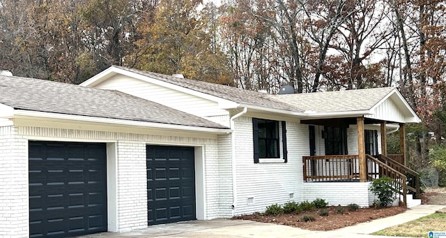 ranch-style home with a porch and a garage