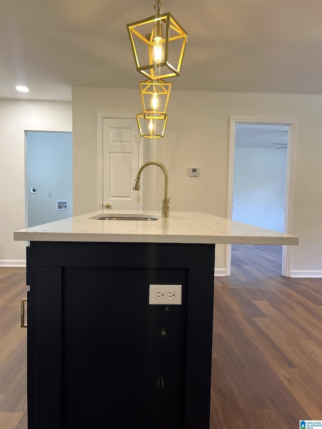 kitchen featuring sink, pendant lighting, a center island with sink, a chandelier, and dark hardwood / wood-style floors