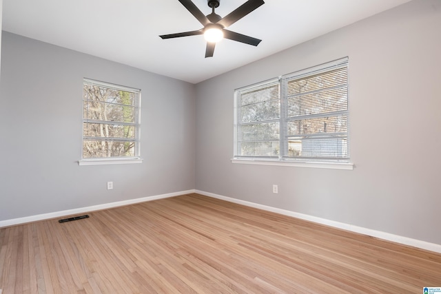 empty room featuring ceiling fan, a healthy amount of sunlight, and light hardwood / wood-style floors