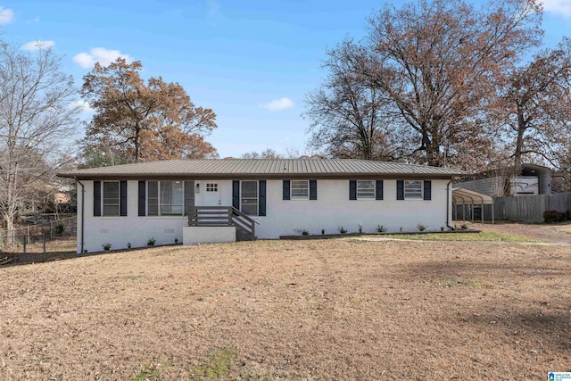 single story home featuring brick siding, metal roof, a front lawn, and fence