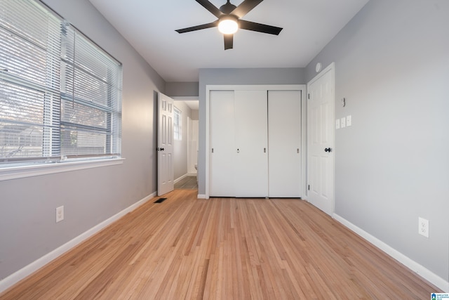 unfurnished bedroom featuring light wood-type flooring, a closet, and ceiling fan