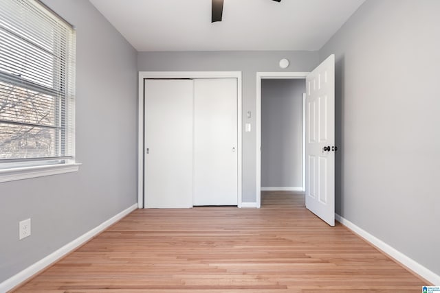 unfurnished bedroom featuring ceiling fan, a closet, and light hardwood / wood-style floors