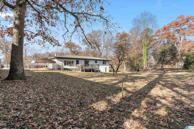 back of house featuring a carport and a lawn