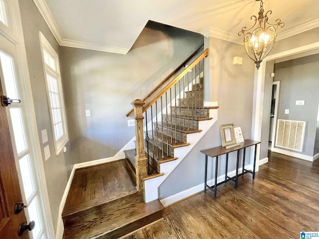 stairway with hardwood / wood-style floors, ornamental molding, and a chandelier