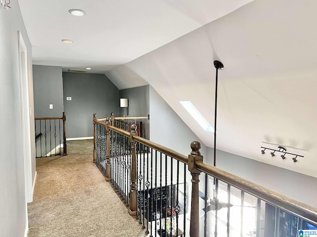 corridor with carpet and lofted ceiling with skylight