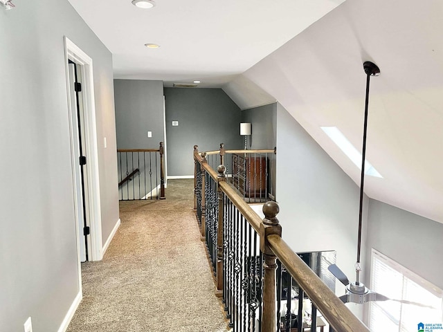 hall with vaulted ceiling with skylight and carpet