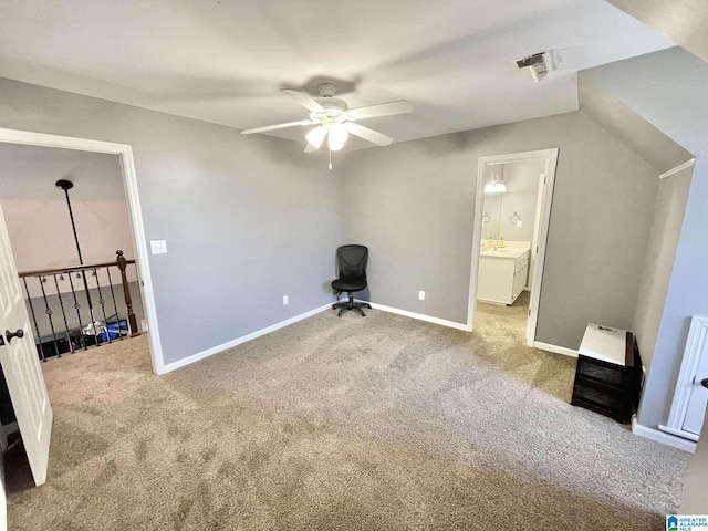 interior space featuring connected bathroom, ceiling fan, heating unit, and carpet floors