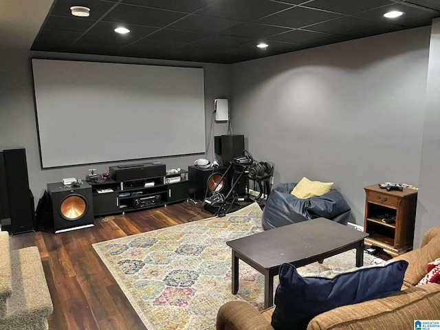 cinema room featuring a drop ceiling and dark hardwood / wood-style floors