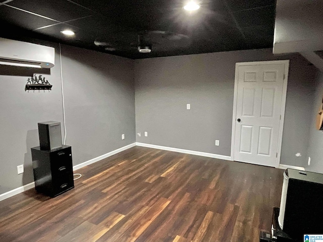 basement featuring dark hardwood / wood-style flooring and a wall unit AC