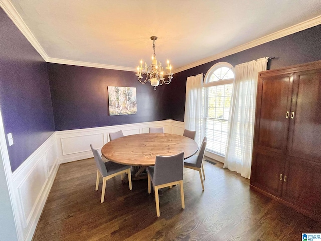 dining area with ornamental molding, dark wood-type flooring, and an inviting chandelier