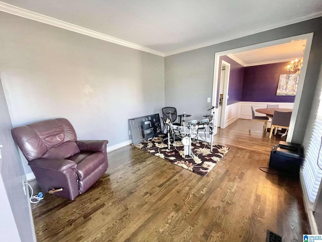 sitting room featuring an inviting chandelier, ornamental molding, and hardwood / wood-style flooring