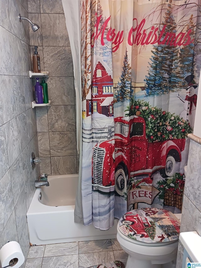 bathroom with shower / tub combo, toilet, and tile walls