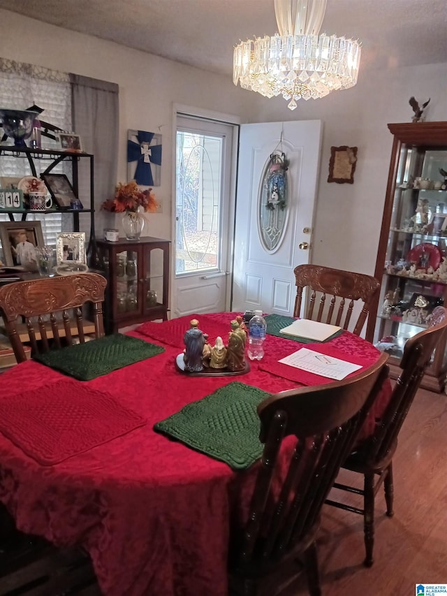 dining space featuring hardwood / wood-style floors and a notable chandelier