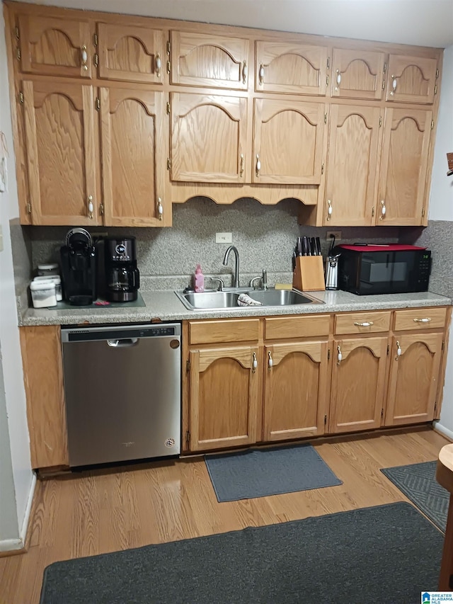 kitchen featuring stainless steel dishwasher, decorative backsplash, light wood-type flooring, and sink