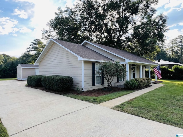 view of front of home featuring a storage unit, covered porch, and a front yard