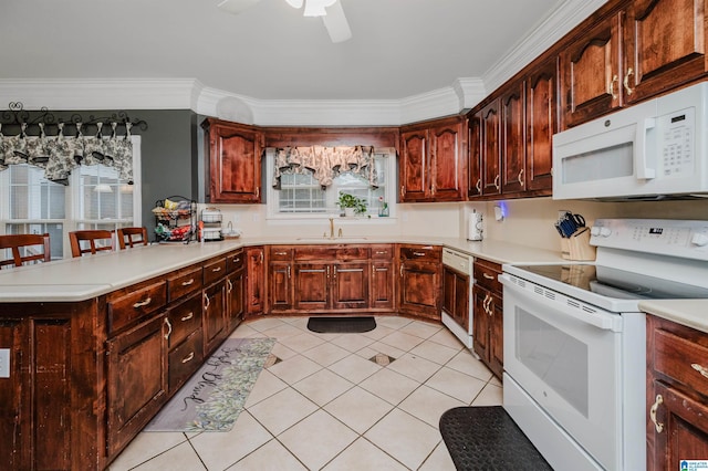 kitchen featuring a breakfast bar, white appliances, sink, crown molding, and kitchen peninsula