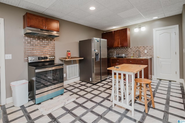 kitchen featuring a drop ceiling, sink, appliances with stainless steel finishes, and tasteful backsplash