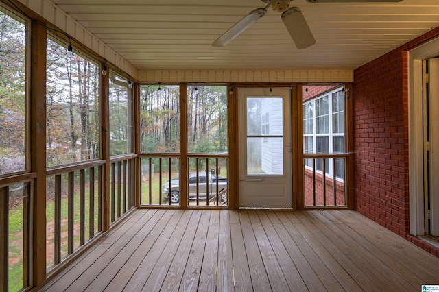 unfurnished sunroom with ceiling fan