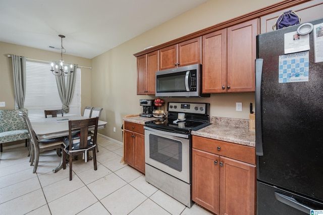 kitchen with pendant lighting, a notable chandelier, light tile patterned floors, and stainless steel appliances