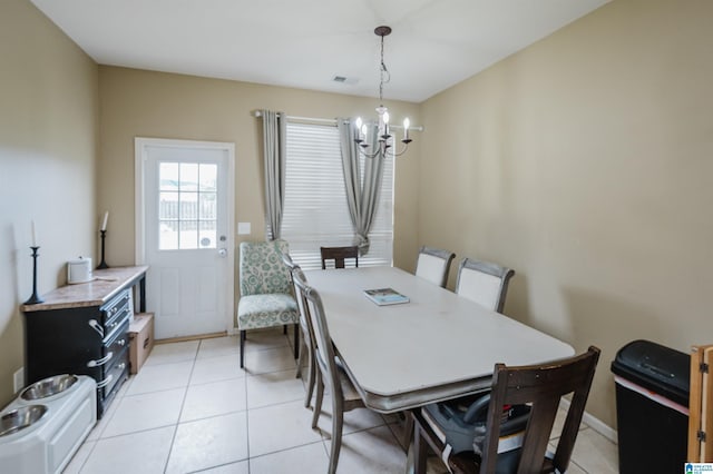 tiled dining room with a notable chandelier