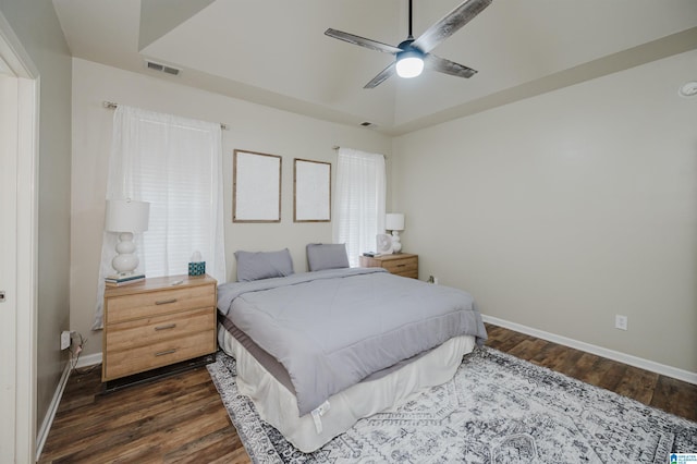 bedroom with ceiling fan, dark hardwood / wood-style flooring, and multiple windows